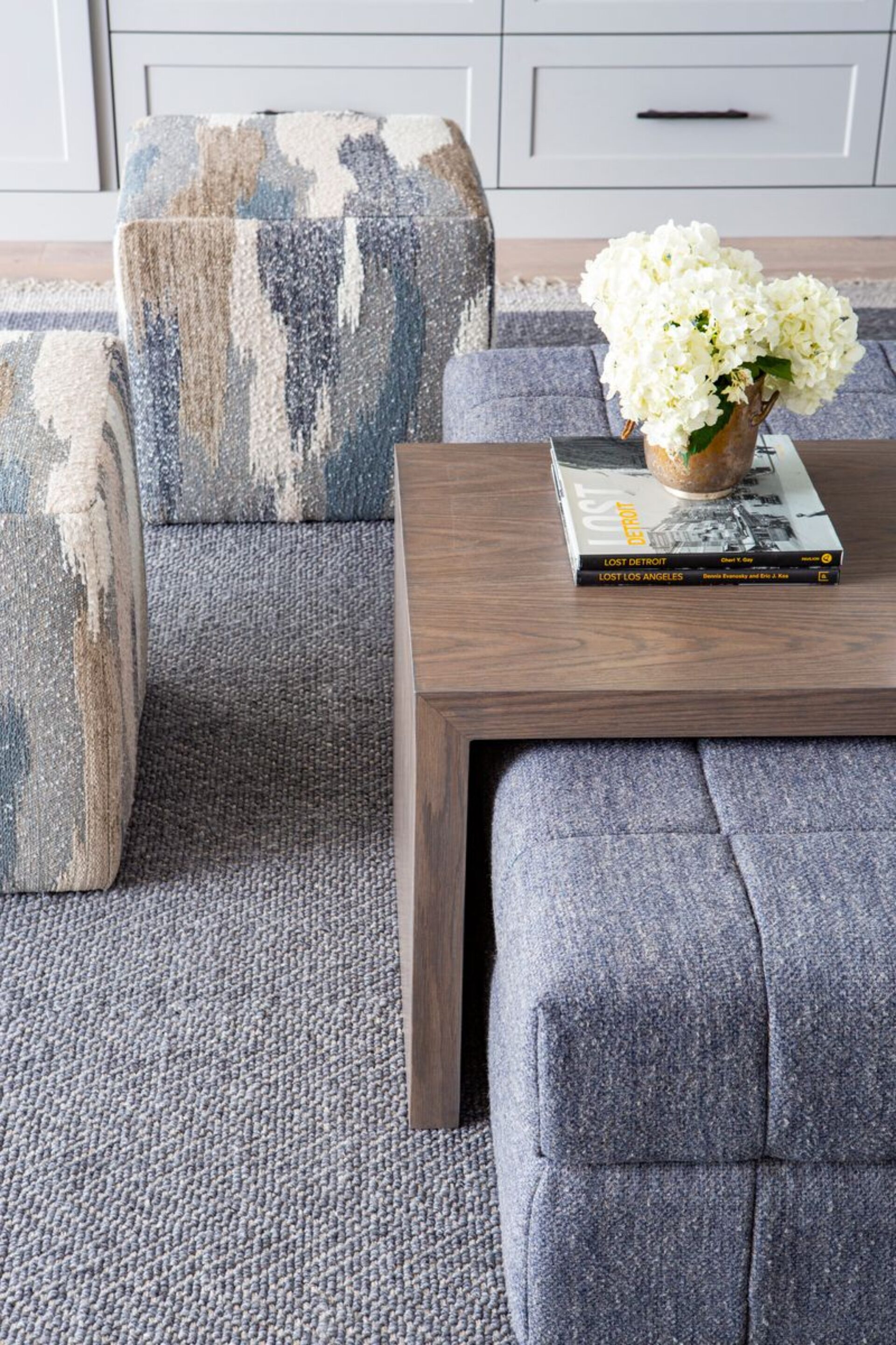 Ottoman Under Coffee Table With Book And Flowers